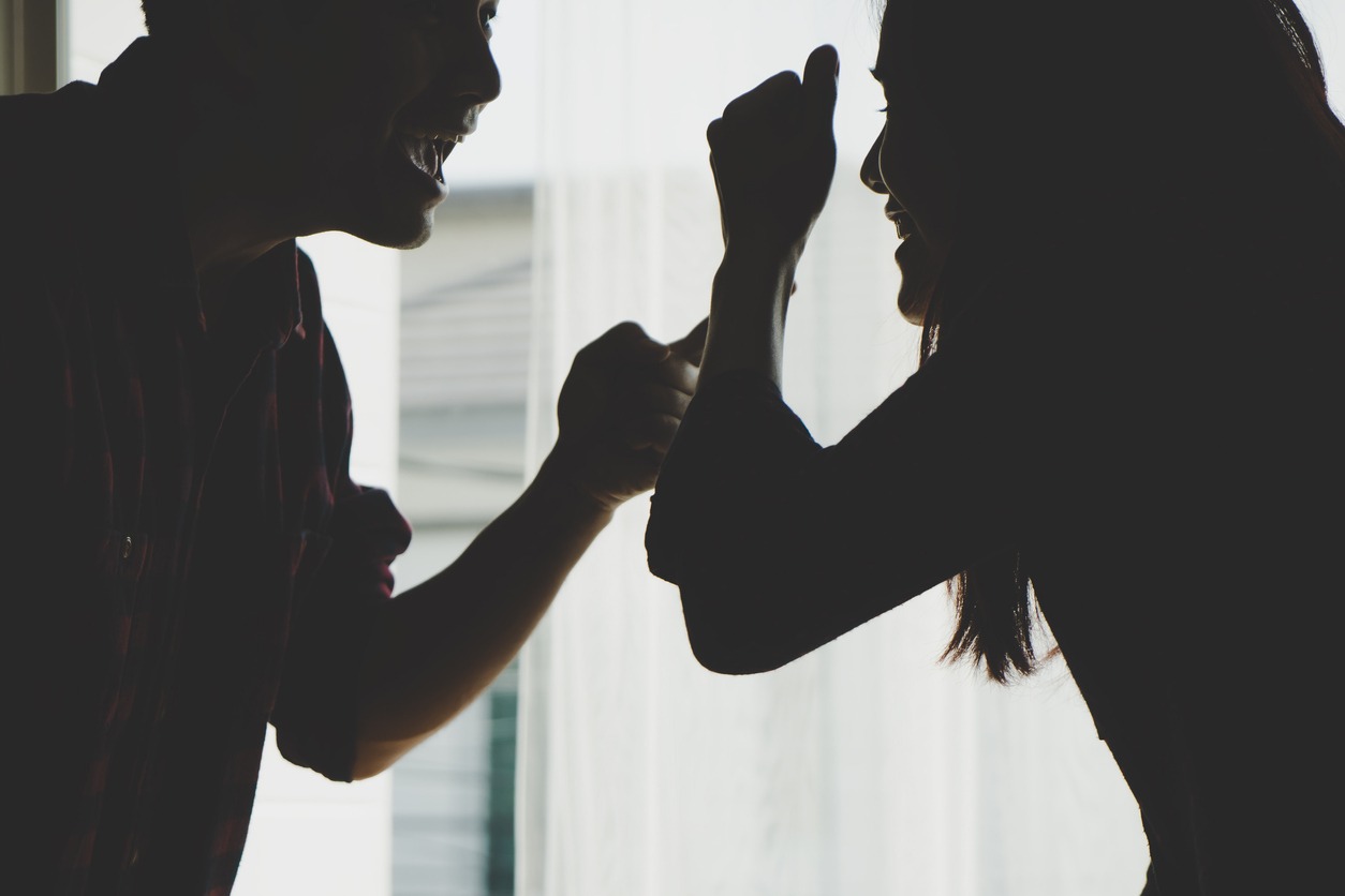 a silhouette of a couple fighting