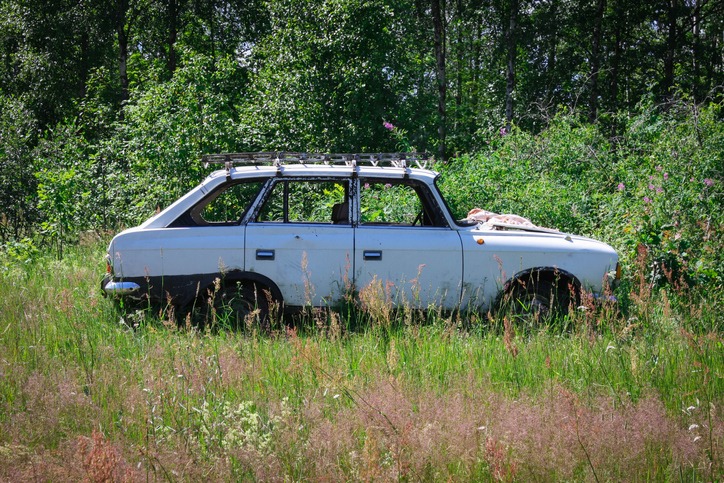 old rusty Soviet car abandoned in the woods in Russia