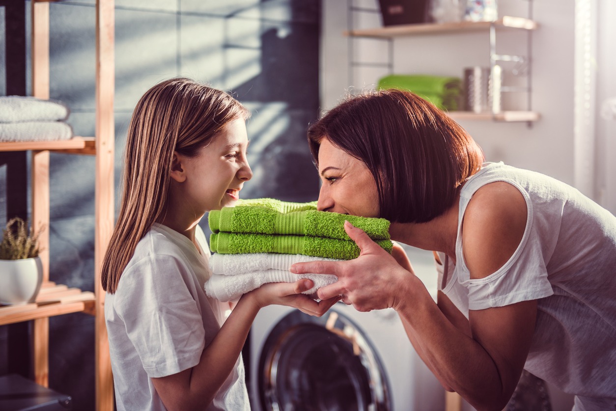 Mother and daughter smelling fresh towels