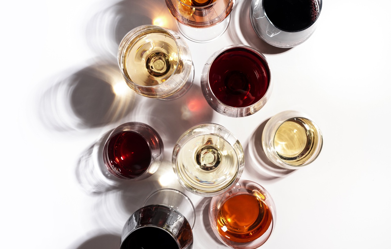 Red, rose and white wine in glasses on white background