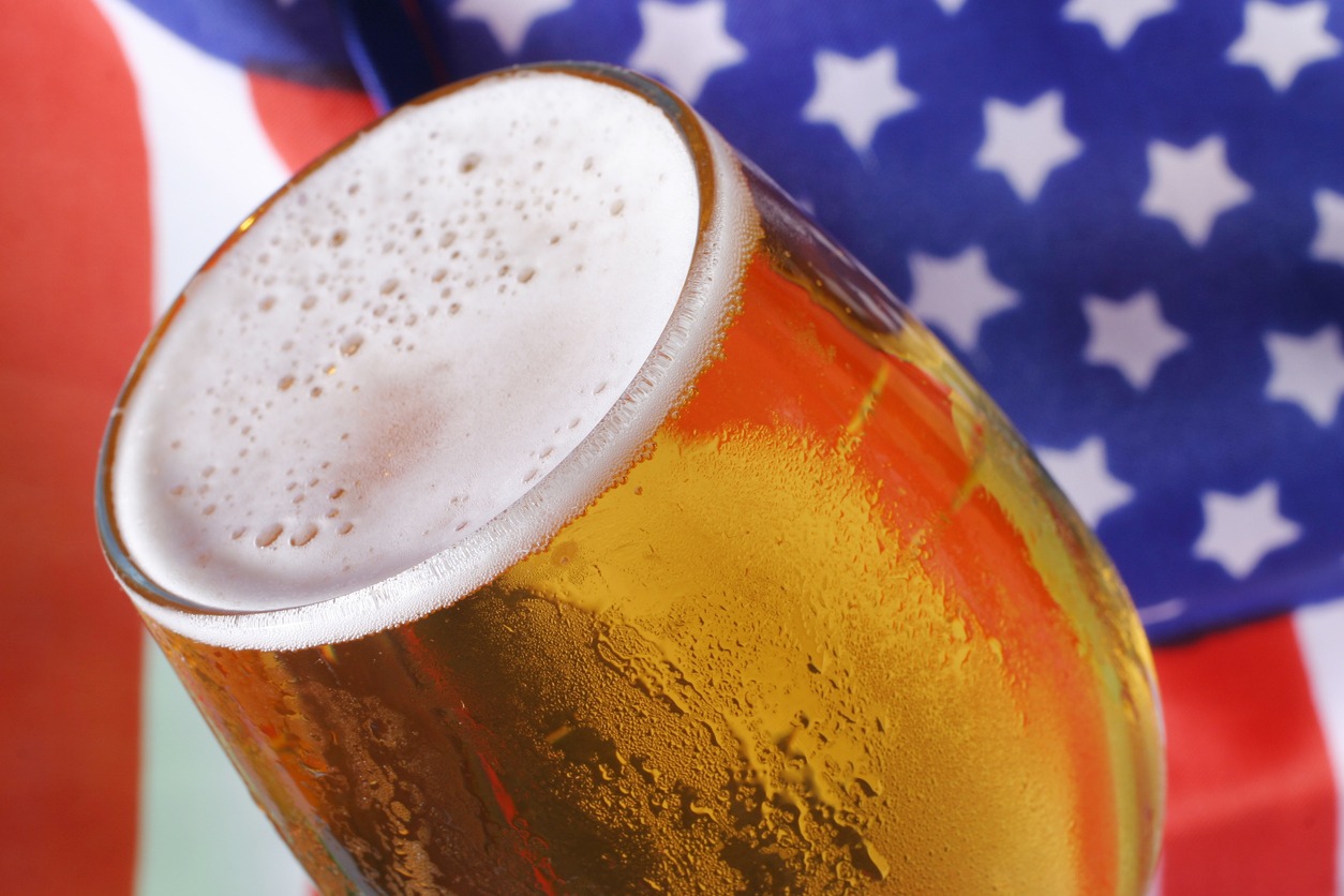 a glass of beer with the American flag on the background