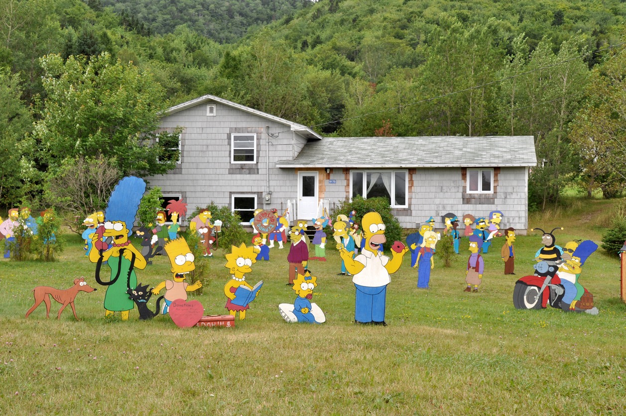 cardboard cut-outs of the Simpsons characters in a garden
