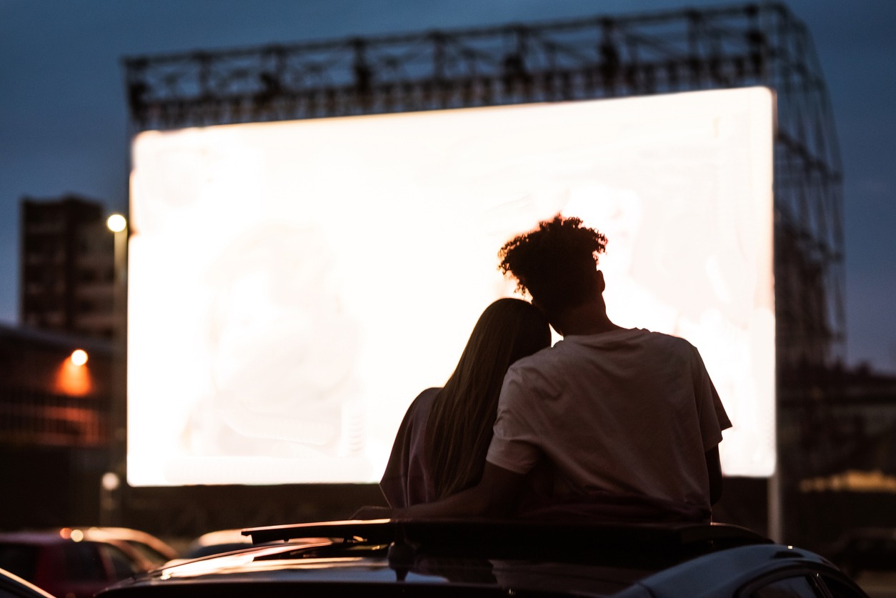 couple watching a movie in a drive-in cinema