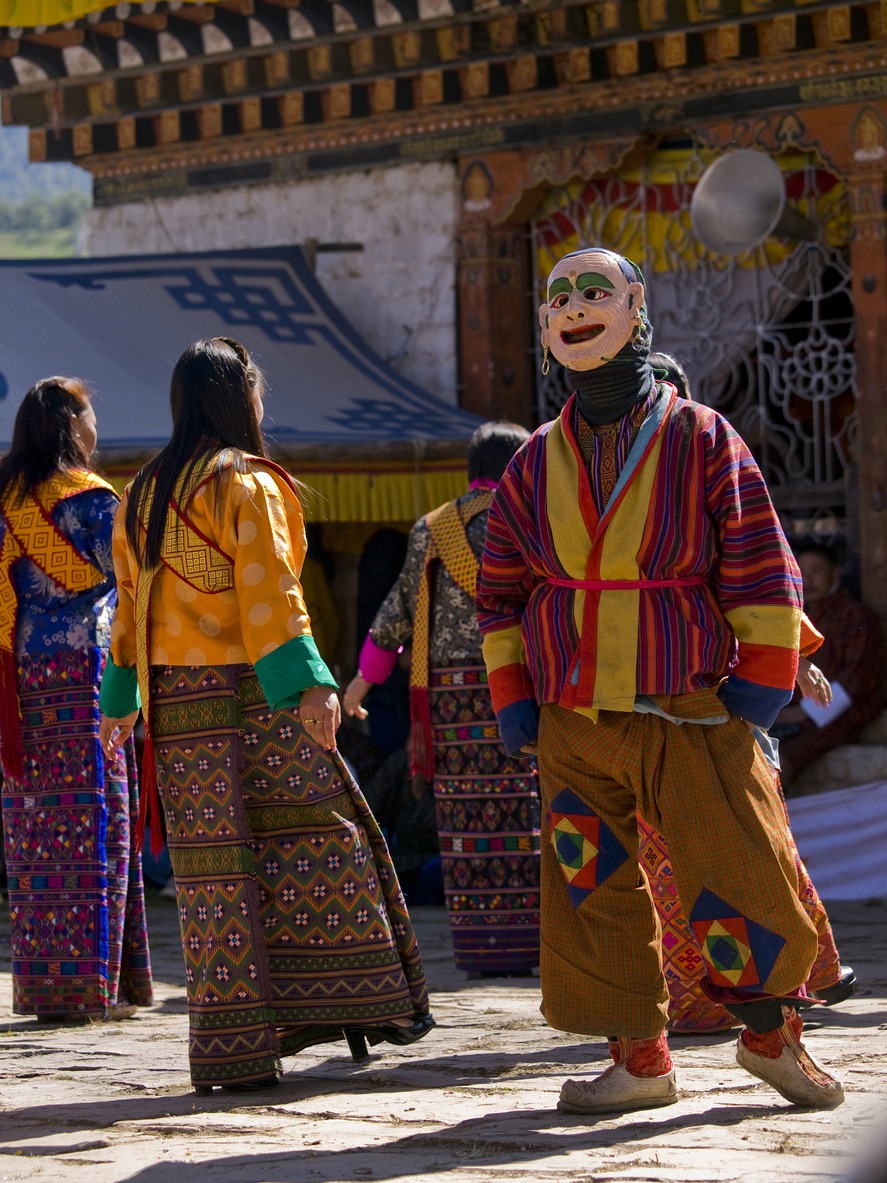 men and women wearing special dresses and are dancing at the Jakar tsechu in Jakar, Bhutan