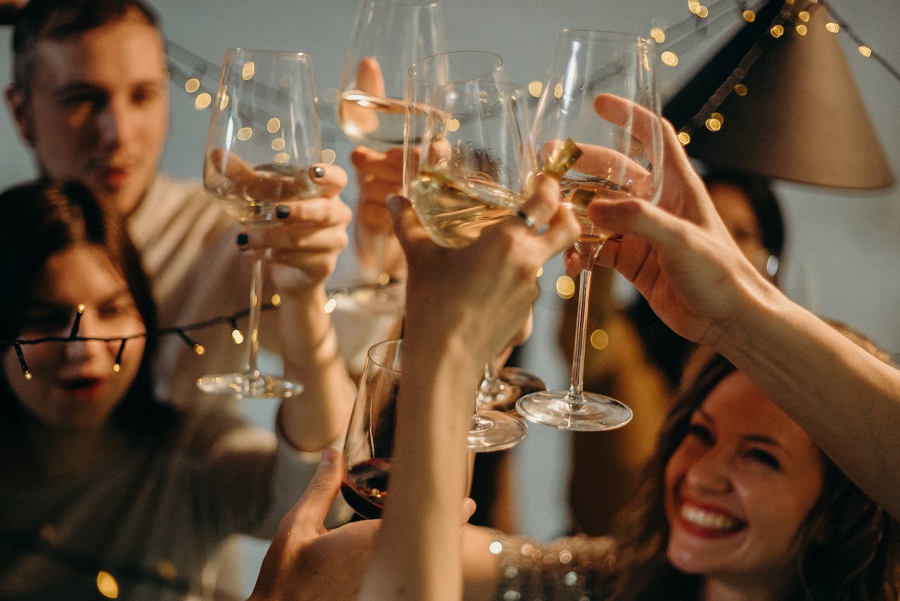 selective focus photography of several people cheering wine glass