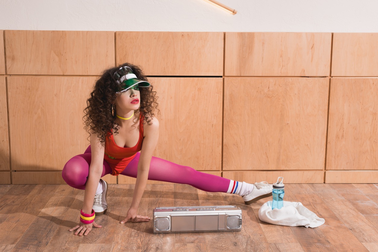 woman in stylish body suit stretching before training