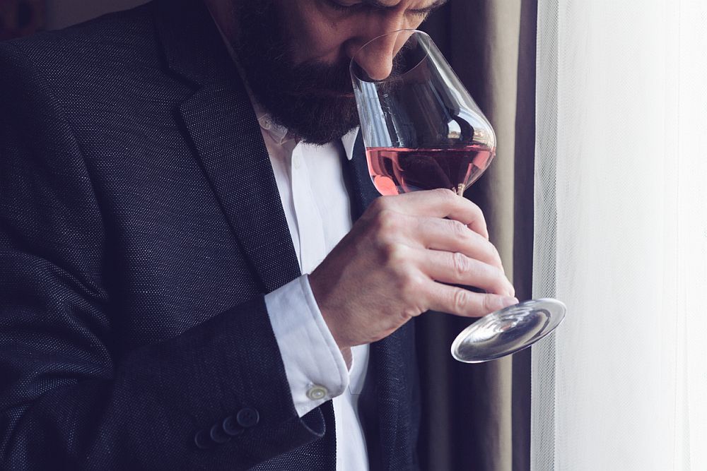 man tasting a glass of rose wine