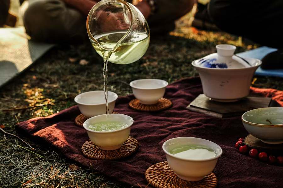 Someone pouring green tea in cups