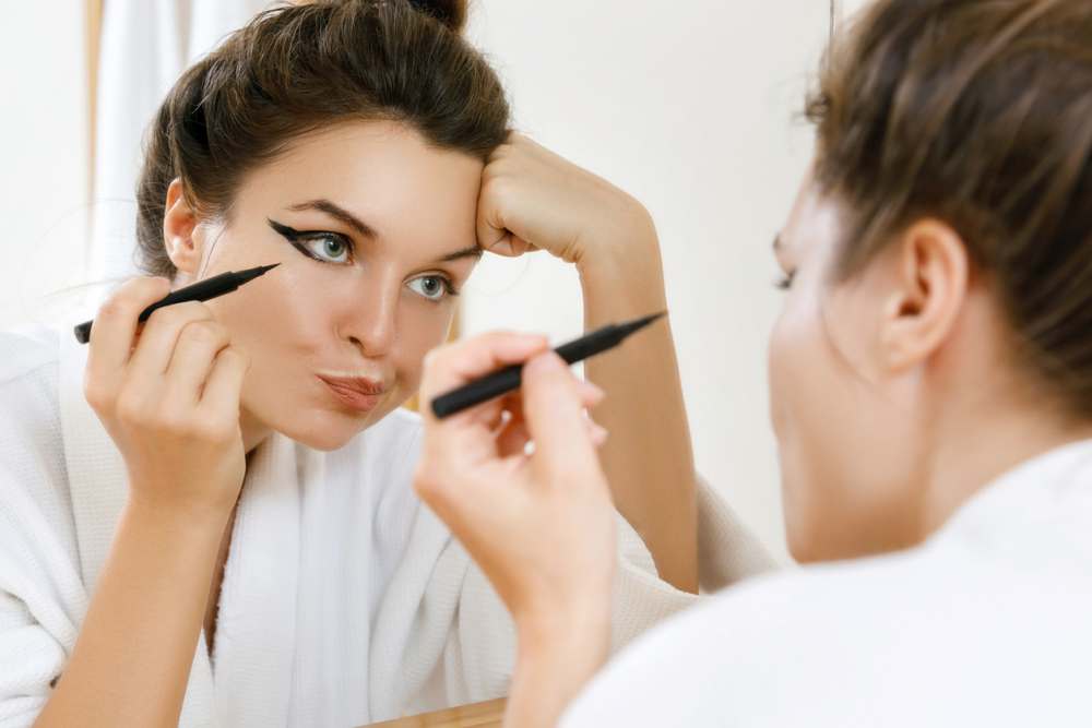 Woman applying thick eyeliner