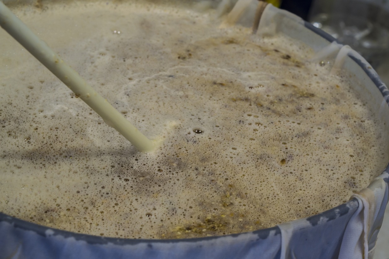 Craft beer production mashing grains in a tank in a microbrewery