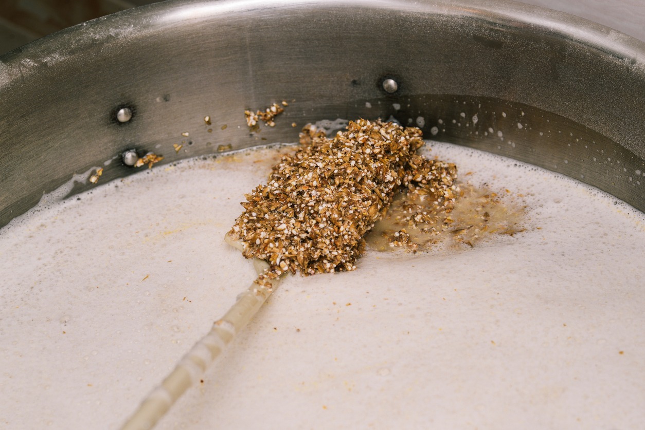 Ground malt in a water tank Ingredients for brewing close-up Beer mashing